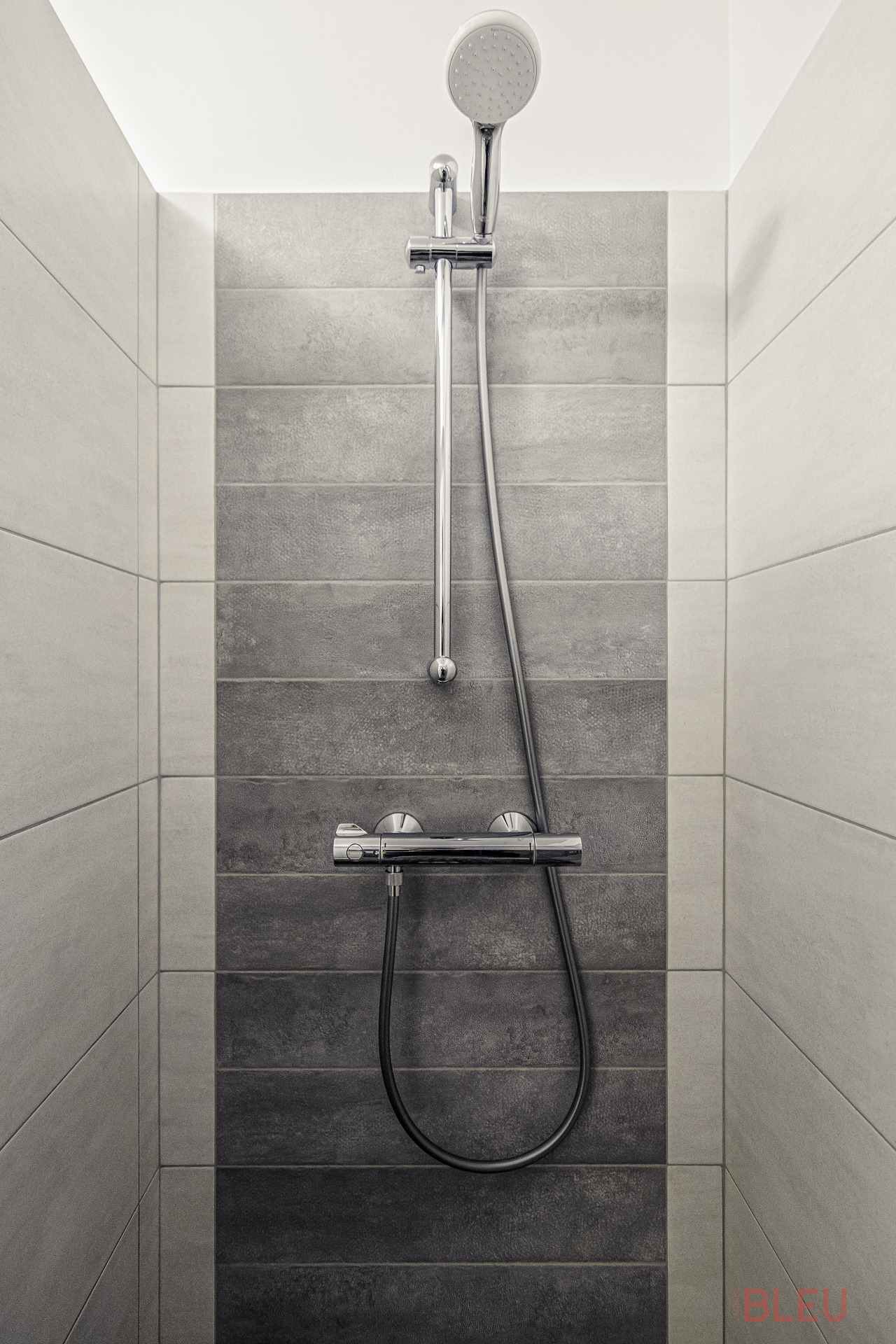 Une grande douche sur rehausse assure un confort optimal avec ses dimensions de 75 cm par 110 cm. Équipée d'une colonne de douche et d'une ventilation, elle offre tous les agréments nécessaires pour les habitants de l'appartement.